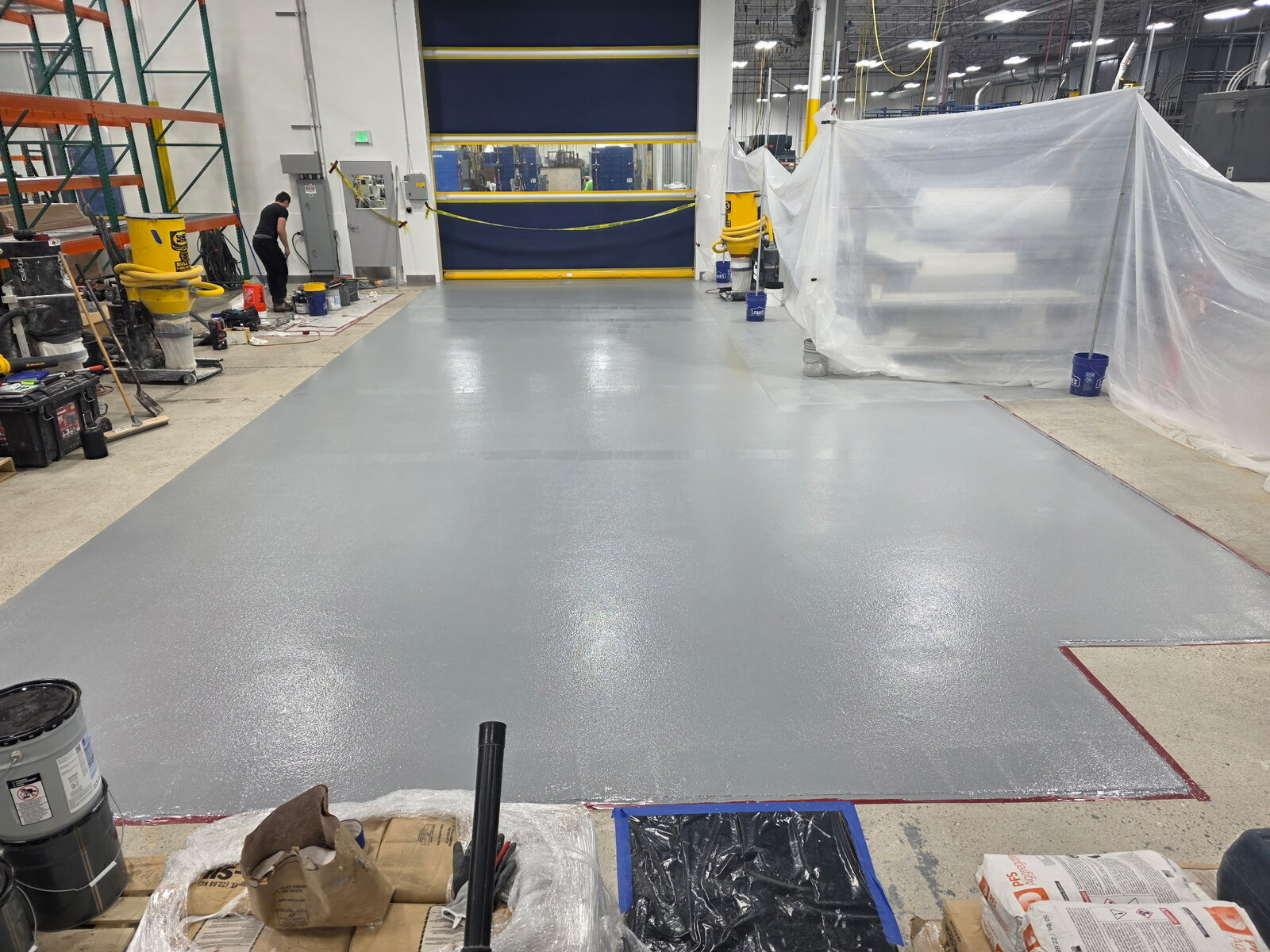 Gray epoxy floor coating in a large manufacturing bay